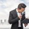 young asian business man looking through a magnifying glass