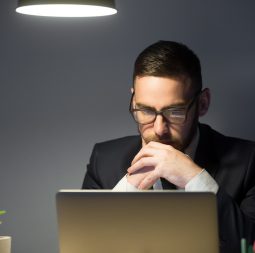 Concerned worker looking at laptop screen, thinking about problem solution, risks, company success strategies, person reading financial report. Concept of hardworking, concentration, making decision