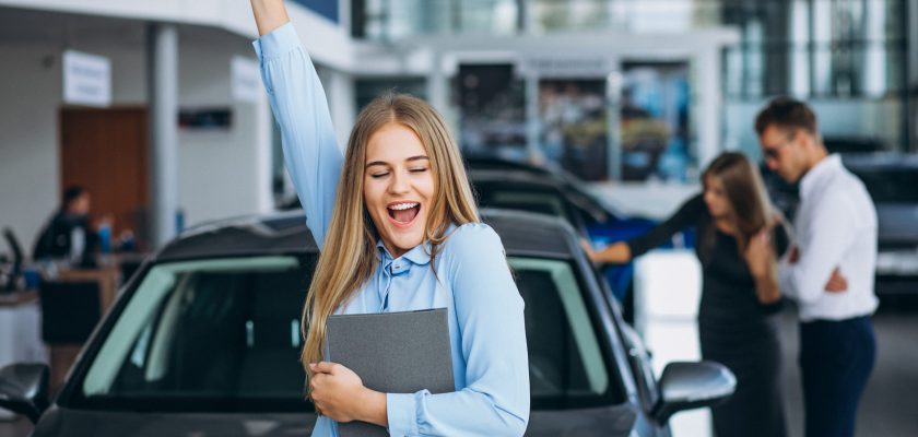 Young family choosing a car in a car showroom